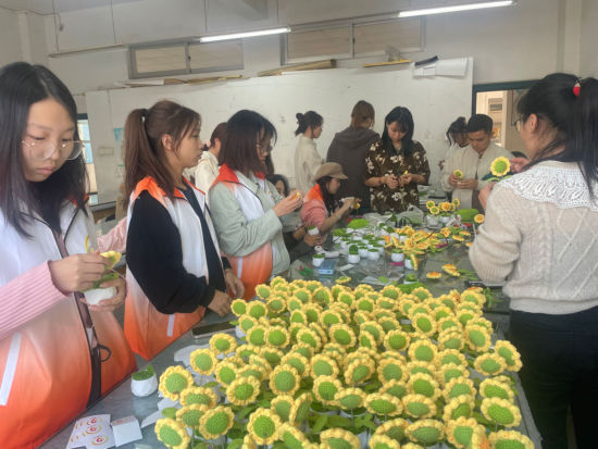 ky官方网站“学雷锋”大学生公益志愿者与脑瘫患儿家长们一起做手工。 ky官方网站供图